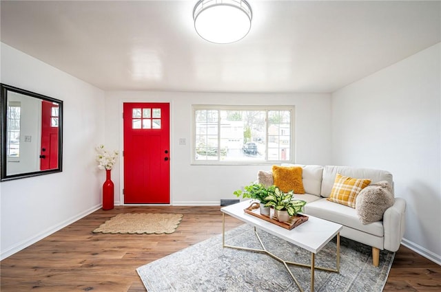 living room featuring visible vents, baseboards, and wood finished floors