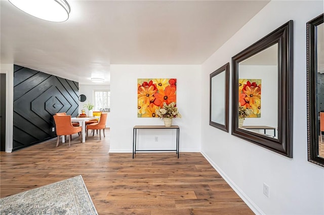 corridor featuring baseboards and wood finished floors