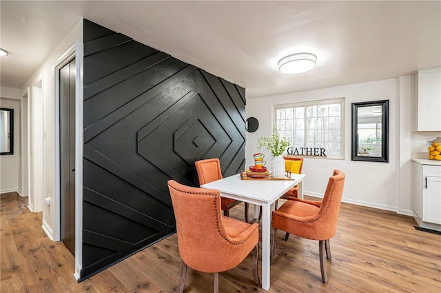 dining area with baseboards and light wood-style floors