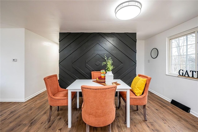 dining area with baseboards and wood finished floors