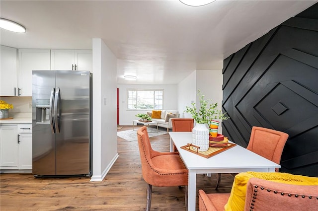 dining space featuring light wood-style flooring and baseboards