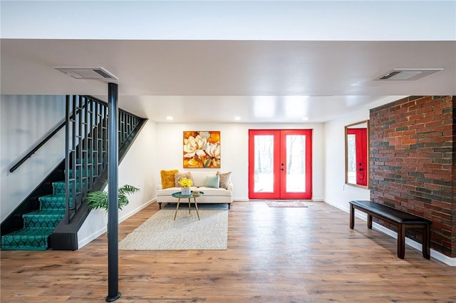 foyer entrance with wood finished floors, visible vents, baseboards, french doors, and stairway