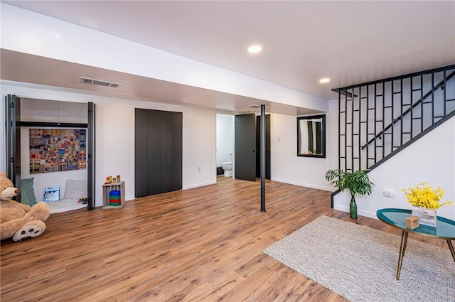 interior space with recessed lighting, visible vents, stairway, wood finished floors, and baseboards