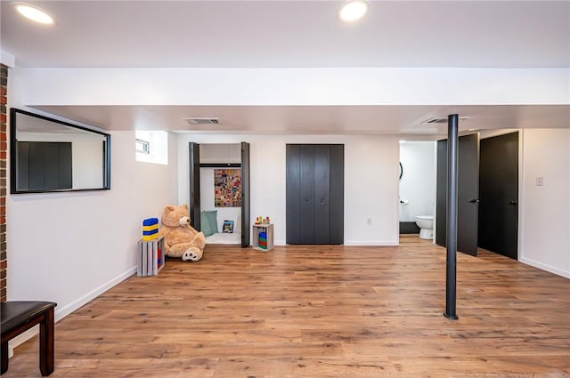 finished basement featuring baseboards, visible vents, wood finished floors, and recessed lighting