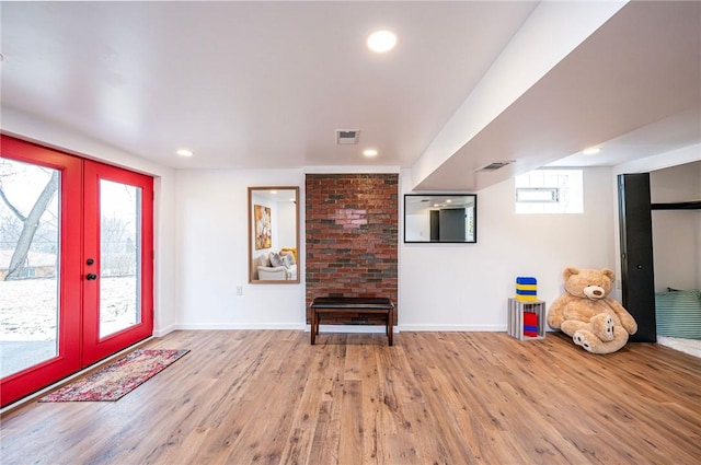 foyer with a wealth of natural light, french doors, visible vents, and wood finished floors