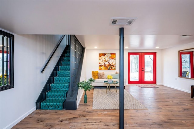 foyer entrance featuring stairs, wood finished floors, and visible vents