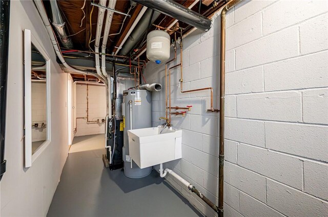 utility room featuring water heater and a sink