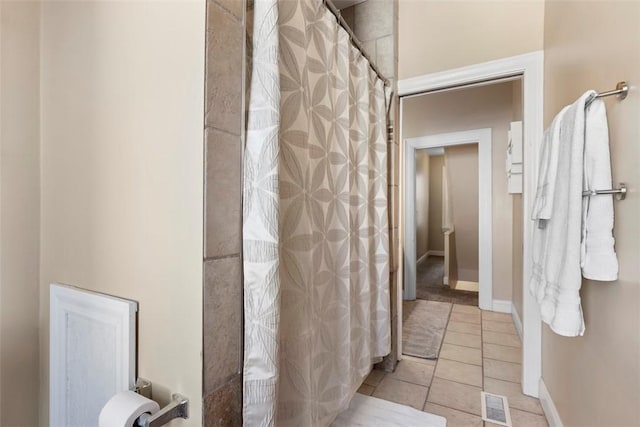 bathroom featuring a shower with curtain, visible vents, baseboards, and tile patterned floors