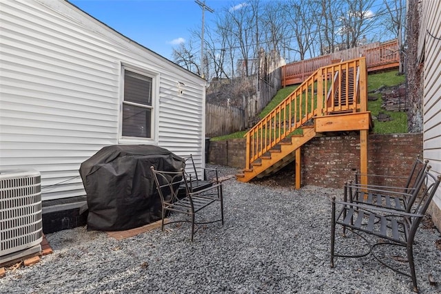 view of patio / terrace with fence, stairway, grilling area, and central AC unit