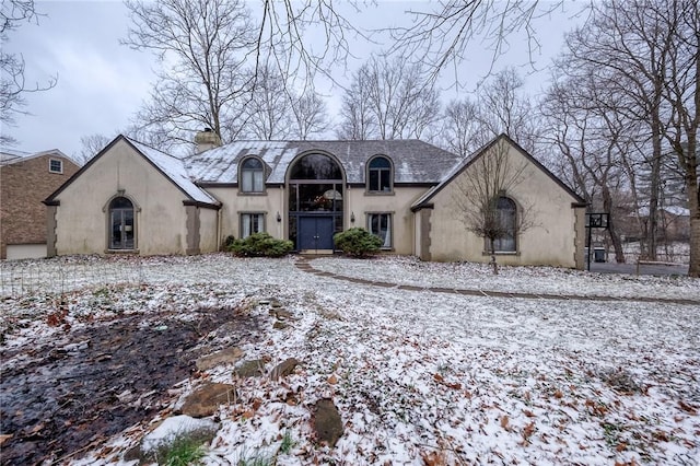 view of front of house featuring a chimney and stucco siding