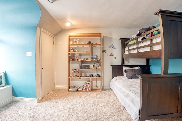 bedroom with carpet flooring, vaulted ceiling, and baseboards