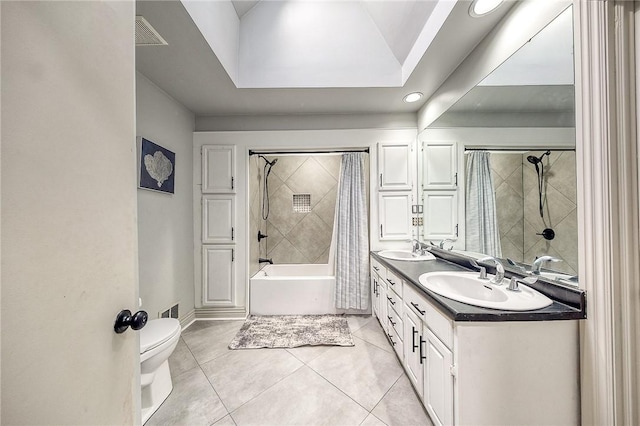 bathroom with shower / tub combo with curtain, tile patterned flooring, a sink, and toilet