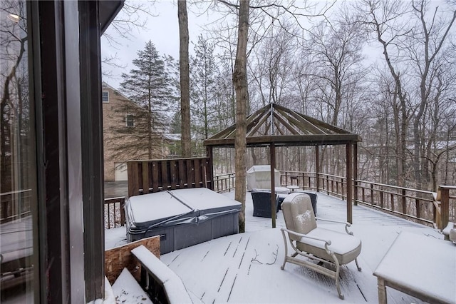 snow covered deck featuring a hot tub and a gazebo