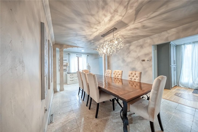 dining room featuring crown molding, a chandelier, visible vents, and ornate columns