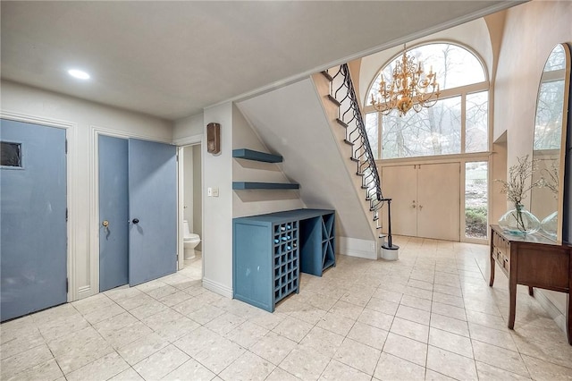 foyer entrance with recessed lighting, light tile patterned floors, baseboards, and stairs