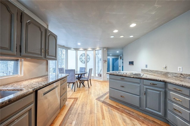 kitchen featuring light wood-type flooring, gray cabinets, plenty of natural light, and stainless steel dishwasher