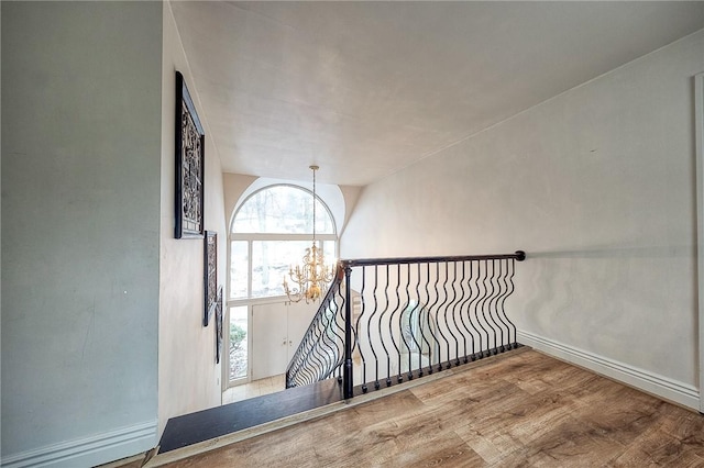 interior space with a chandelier, baseboards, and wood finished floors