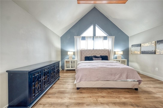 bedroom with lofted ceiling, baseboards, and wood finished floors