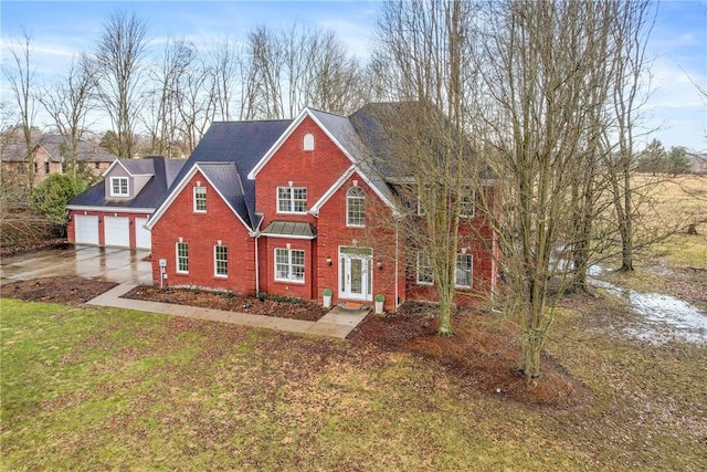 traditional-style home featuring concrete driveway, brick siding, a front lawn, and an attached garage