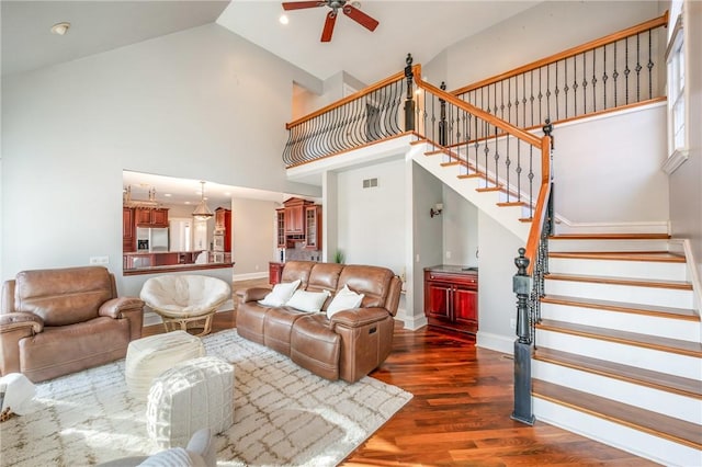 living area featuring dark wood-style flooring, stairway, and baseboards