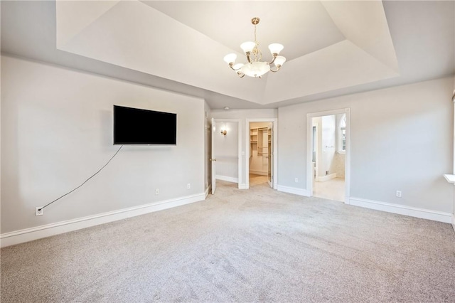 interior space featuring baseboards, a raised ceiling, and a chandelier