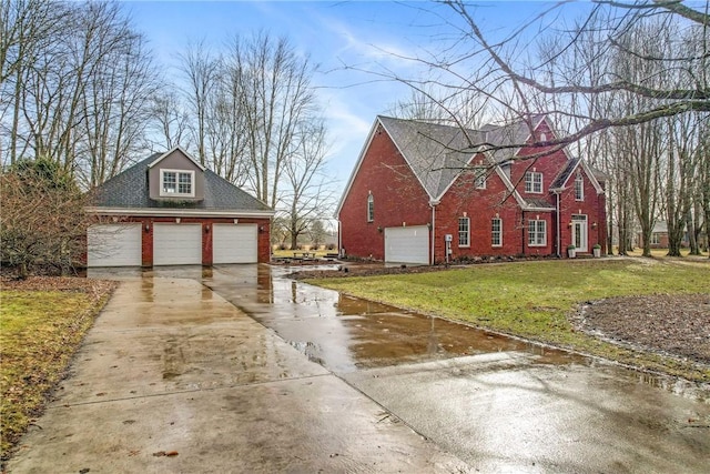 view of home's exterior featuring a yard, a detached garage, and brick siding