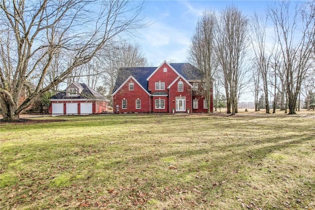 view of front of home featuring an outbuilding, a front lawn, and brick siding