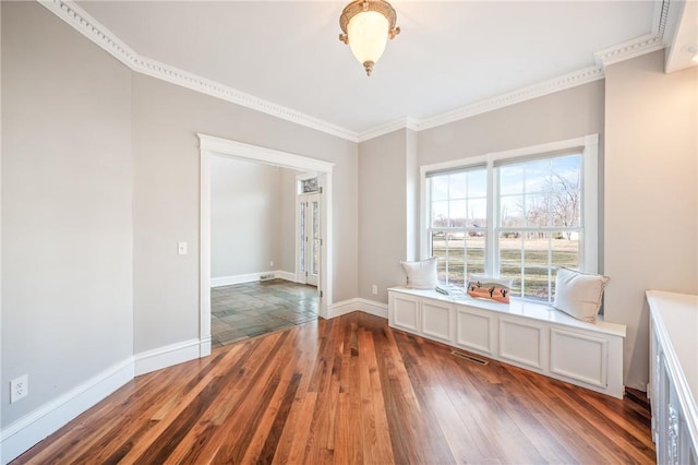 interior space featuring wood-type flooring, visible vents, baseboards, and crown molding