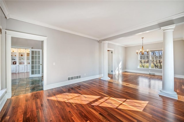 unfurnished room with decorative columns, visible vents, an inviting chandelier, wood finished floors, and baseboards