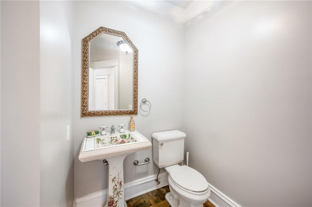 bathroom with toilet and baseboards