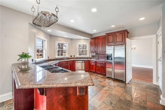 kitchen featuring recessed lighting, dark brown cabinets, stainless steel fridge, a peninsula, and baseboards