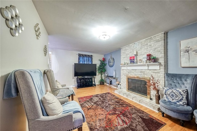 living area with a fireplace and wood finished floors