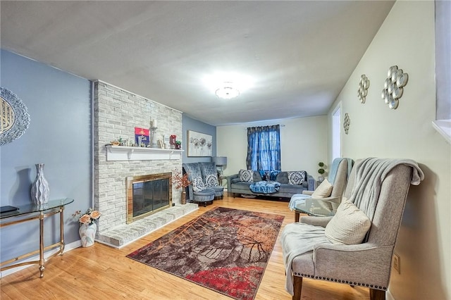 living room featuring a fireplace, wood finished floors, and baseboards