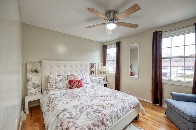 bedroom featuring light wood-style floors, ceiling fan, and baseboards