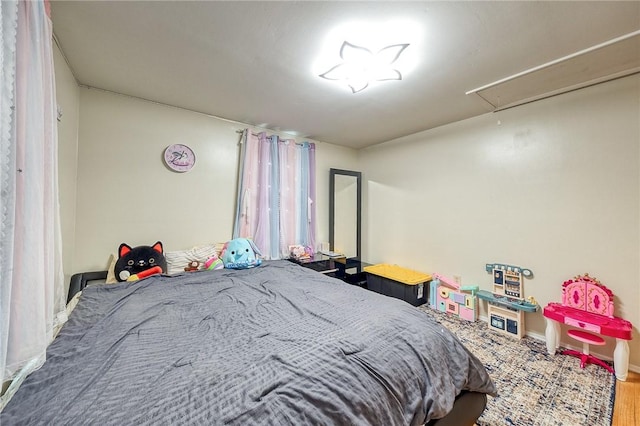 bedroom featuring attic access and baseboards