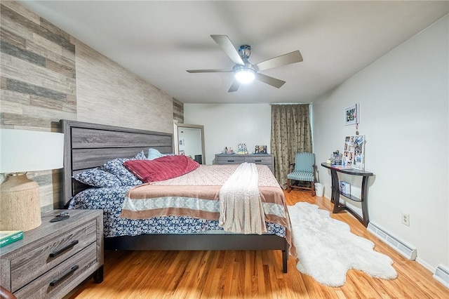 bedroom featuring a ceiling fan, baseboards, visible vents, and wood finished floors