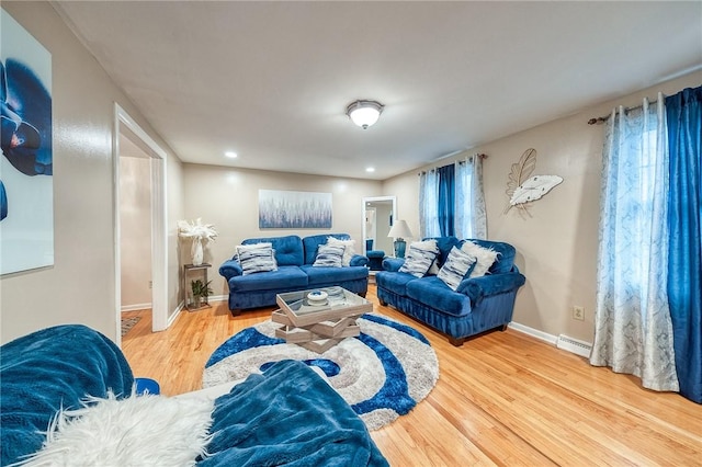 living room with recessed lighting, a baseboard radiator, baseboards, and wood finished floors