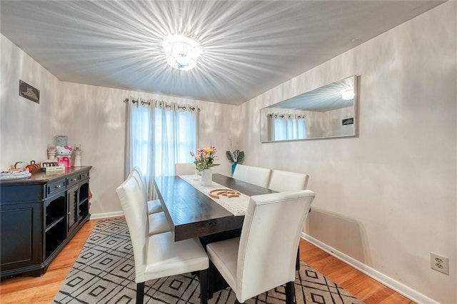 dining space featuring baseboards and light wood-style floors