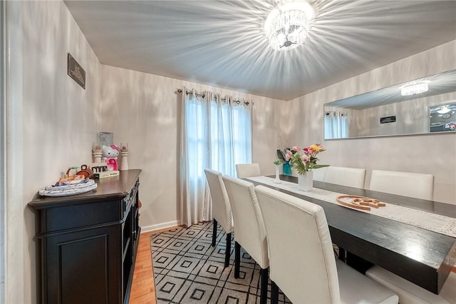 dining space with light wood finished floors and baseboards