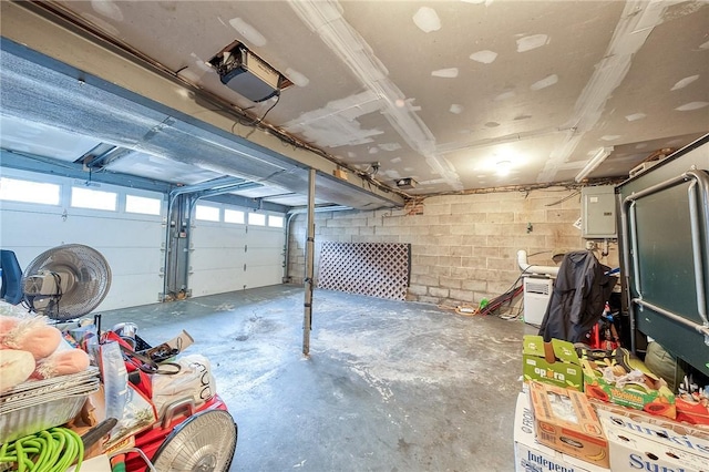 garage featuring a garage door opener and concrete block wall