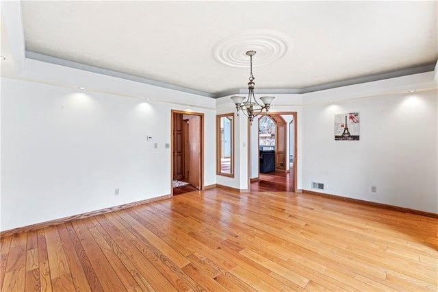 unfurnished dining area with visible vents, a chandelier, light wood-style flooring, and baseboards