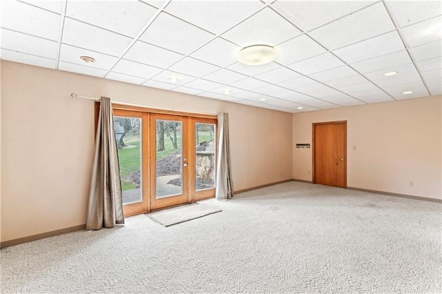 spare room featuring carpet, french doors, a paneled ceiling, and baseboards