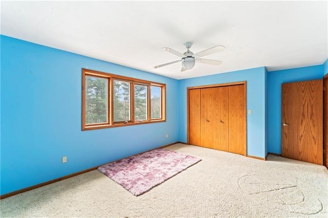 unfurnished bedroom with carpet floors, a ceiling fan, baseboards, and a closet