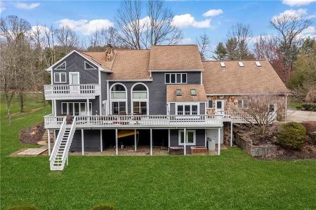 rear view of property featuring a yard, stairway, roof with shingles, a wooden deck, and a chimney