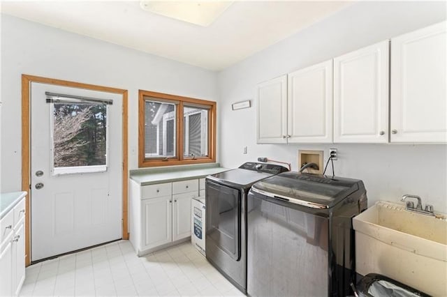 washroom featuring cabinet space, a sink, and separate washer and dryer