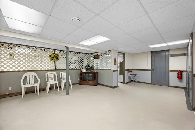 interior space featuring baseboards and a drop ceiling