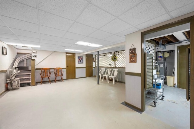 finished basement with stairs and a drop ceiling