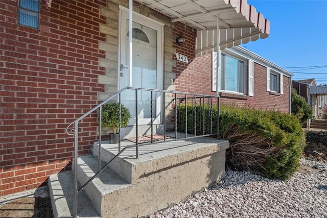 view of exterior entry featuring brick siding