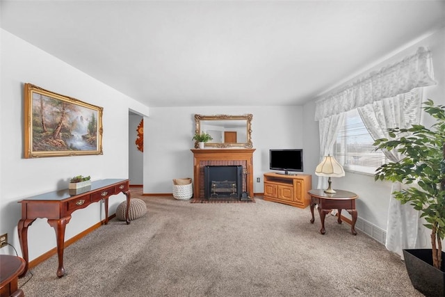 sitting room featuring a brick fireplace, carpet flooring, and baseboards