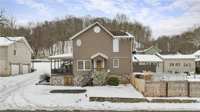 view of front of property with a garage, a porch, and fence